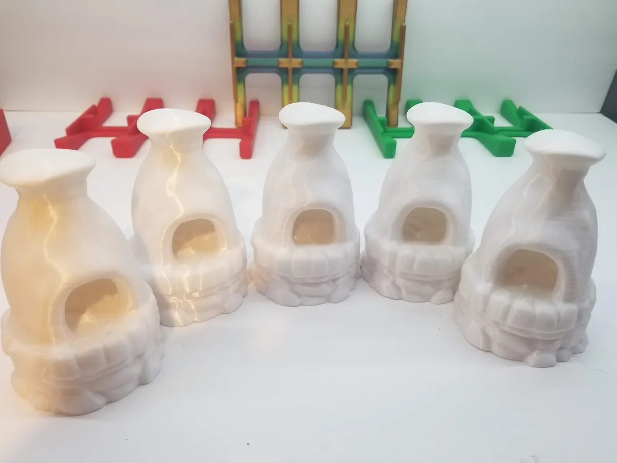 Several white printed furnace shells before painting and final assembly.