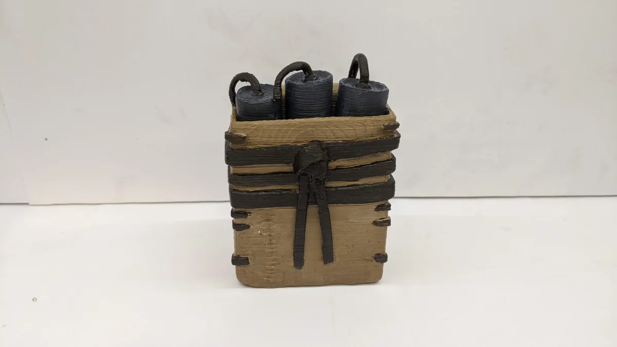A completed satchel prop with a tan body, dark brown straps, and black details.